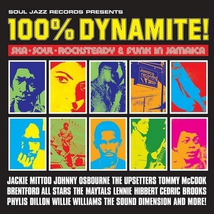 Album cover for '100% Dynamite!' featuring a black background, large yellow title text, a red banner, and a grid of colorful pop-art portraits in blue, green, yellow, orange, and pink. Text at the bottom lists featured artists and genres.